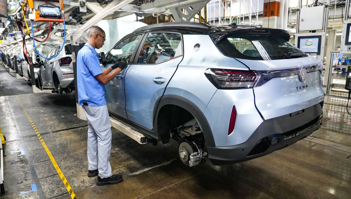 Linha de montagem da volkswagen, onde o Tera aparece sendo montado por um funcionário